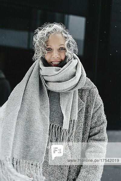 Smiling woman with gray hair wrapped in scarf