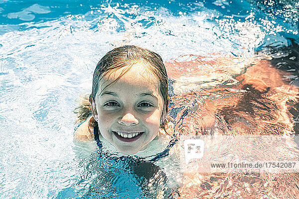 Smiling girl enjoying in swimming pool