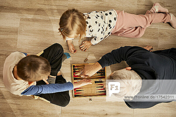 Großvater bringt seinen zu Hause liegenden Enkelkindern Backgammon bei