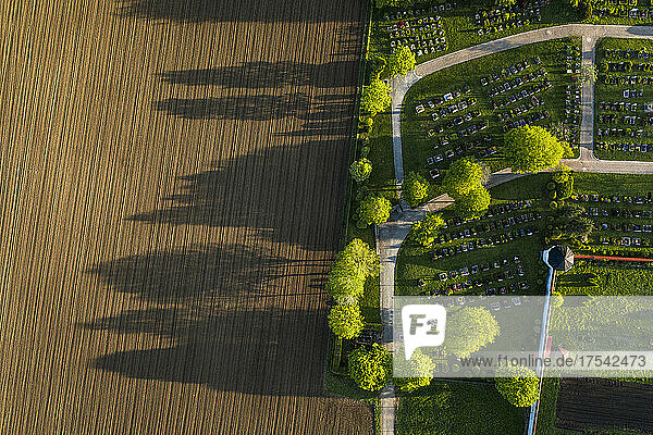 Germany  Bavaria  Berg  Aerial view of plowed field next to countryside cemetery