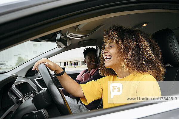 Cheerful young woman with friend in car