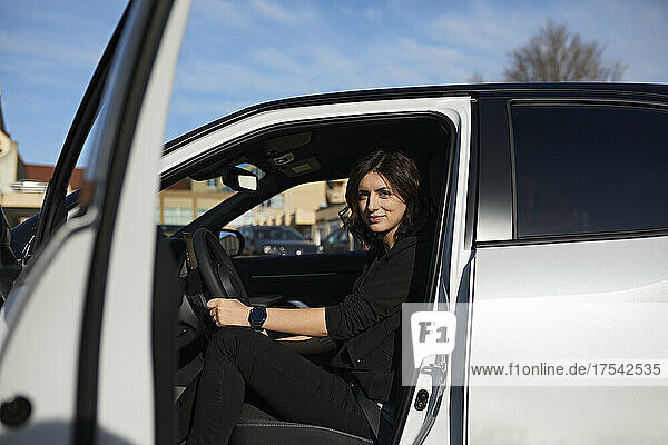 Businesswoman sitting at driver seat in car