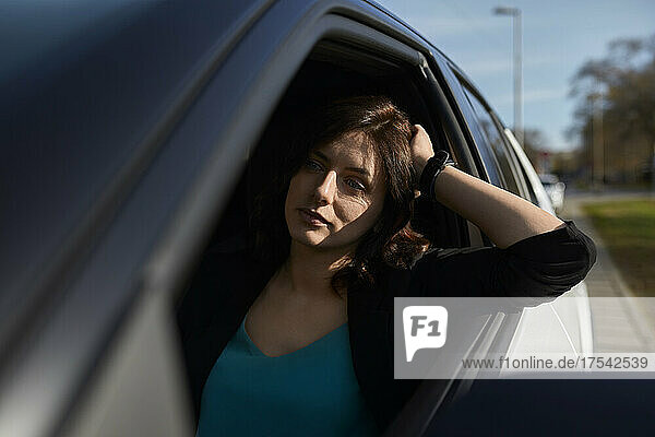 Thoughtful businesswoman leaning on car window