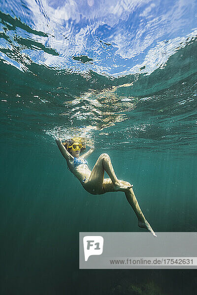 Carefree young woman swimming undersea