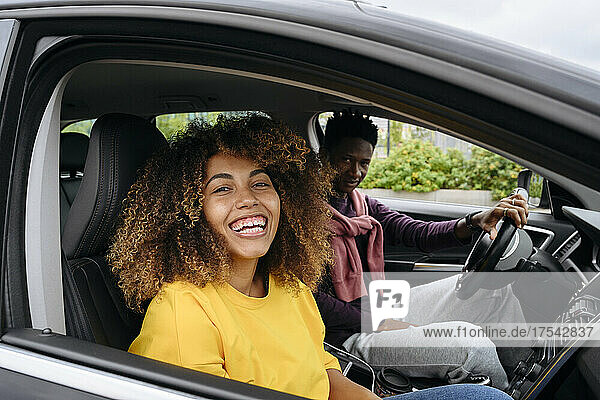 Lächelnde Frau mit Freundin im Auto sitzend