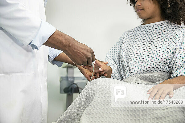 Doctor removing pulse oximeter from patient finger at hospital
