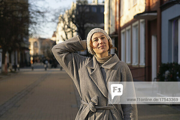 Junge Frau mit der Hand hinter dem Kopf auf der Straße