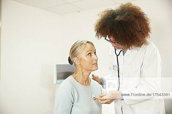 Arzt untersucht Patienten mit Stethoskop im Krankenzimmer