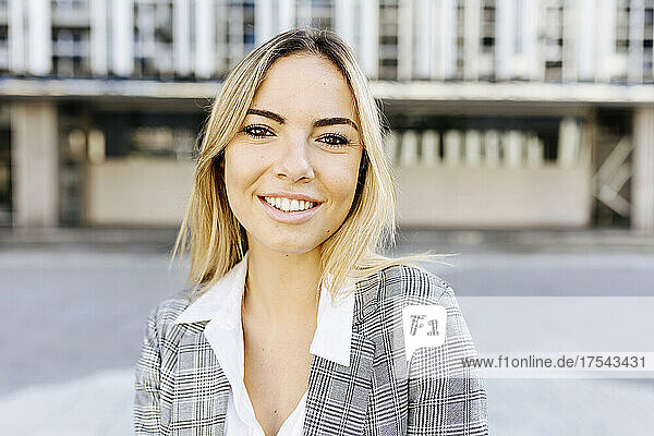 Lächelnde junge Geschäftsfrau mit blonden Haaren