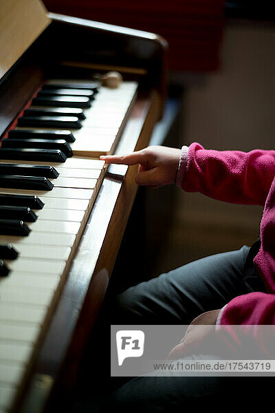 Hand of girl (4-5) playing piano