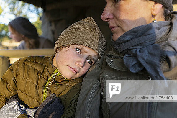 Close up of a boy and his mother in a safari jeep in early morning sun.