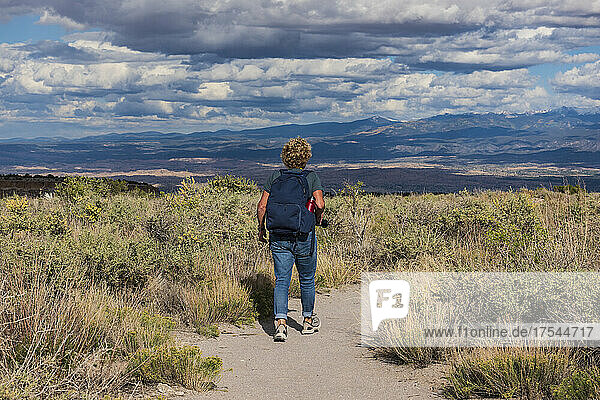 USA  New Mexico  Los Alamos  Rear view of woman hiking in Tsankawi section of Bandelier National Monument