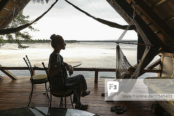 Africa  Zambia  Livingstone  Brother (8-9) and sister (16-17) relaxing in lodge by Zambezi River