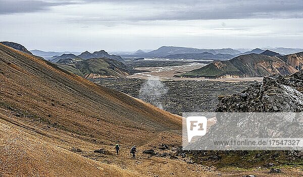 Zwei Wanderer auf dem Laugavegur  Landschaft bei Landmannalaugar  Dramatische Vulkanlandschaft  bunte Erosionslandschaft mit Bergen  Lavafeld  Landmannalaugar  Fjallabak Naturreservat  Suðurland  Island  Europa