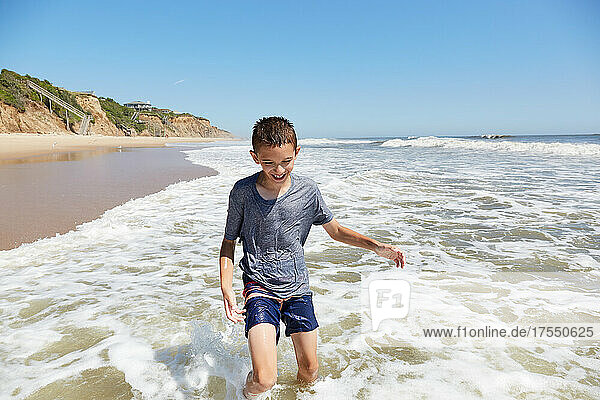 USA  New York  Montauk  Smiling boy (8-9) playing in sea waves