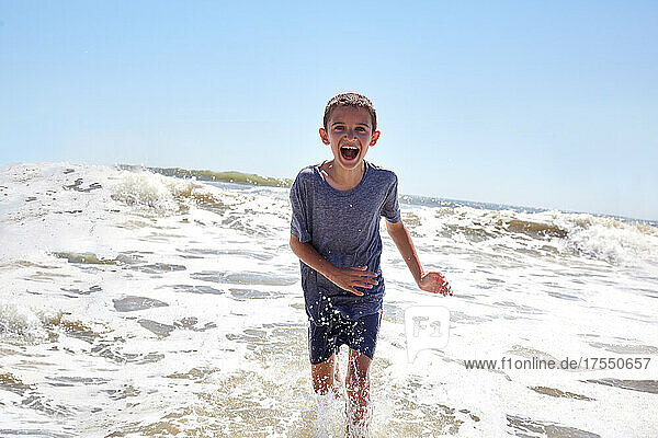 Portrait of smiling boy (8-9) playing in sea waves