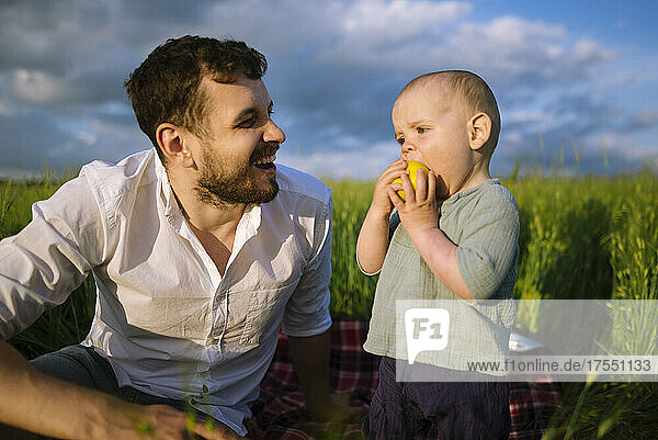 Father with baby son (12-17 months) in agricultural field