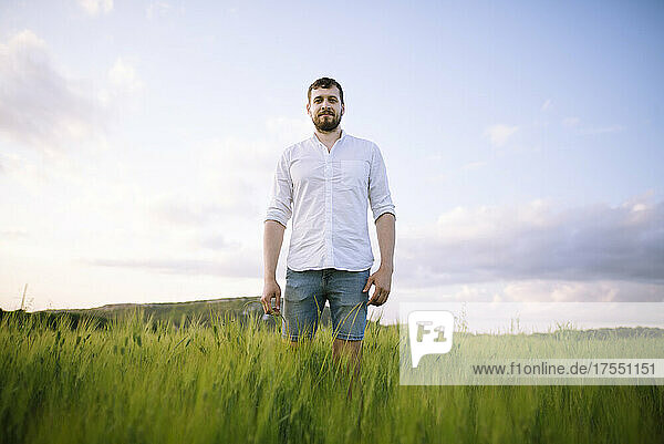 Mid adult man standing in agricultural field