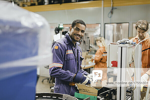 Porträt eines lächelnden männlichen Arbeiters  der in der Industrie arbeitet