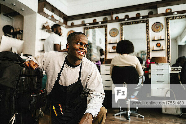Smiling male hairdresser looking away in barber shop