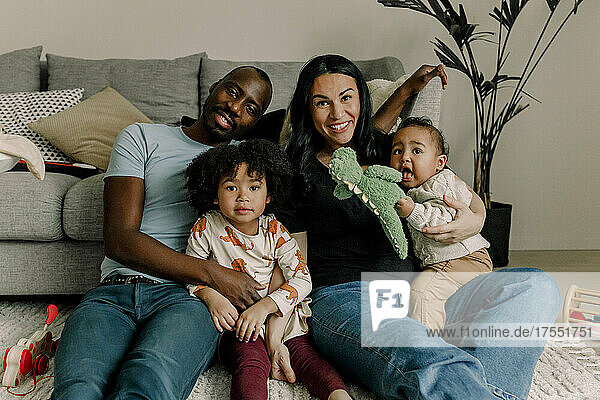 Porträt einer lächelnden gemischtrassigen Familie im Wohnzimmer