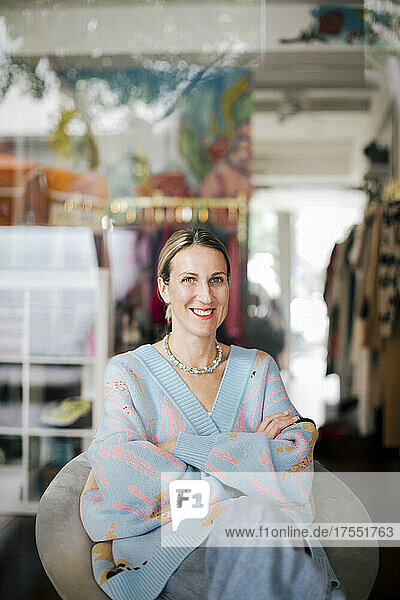 Porträt einer Unternehmerin  die in einem Bekleidungsgeschäft sitzt