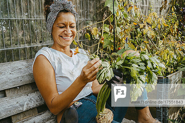 Glückliche Umweltschützerin mit Gemüse auf einem städtischen Bauernhof