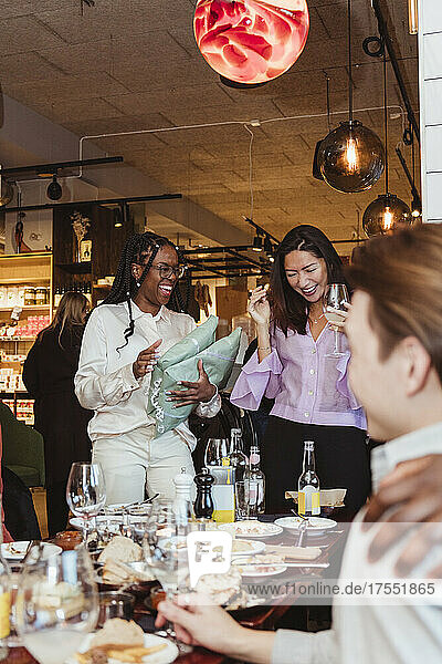 Multirassische Freundinnen lachen beim Feiern während einer Dinnerparty