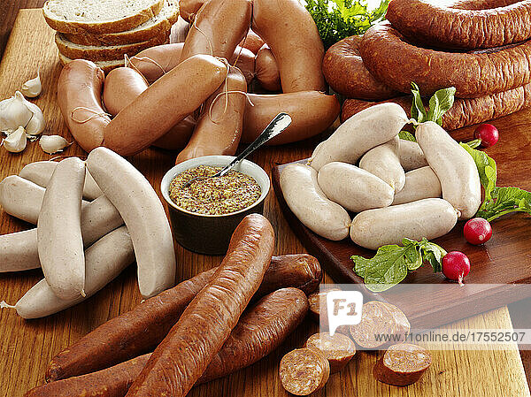 Assortment of raw ethnic sausages with course grain mustard radish and rye bread