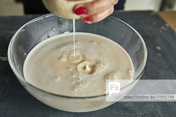 Straining the mixed almonds through gauze. Making almond milk.
