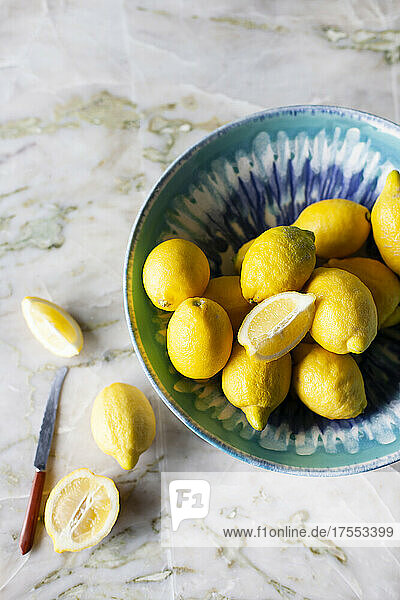 Frische Zitronen in einer Schale und auf Marmoruntergrund