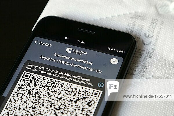FFP2-Maske und iPhone mit Corona-Warn-App mit QR-Code für Genesenenzertifikat  Symbolbild Smartphone-Apps zum Schutz gegen Covid-19  Deutschland  Europa
