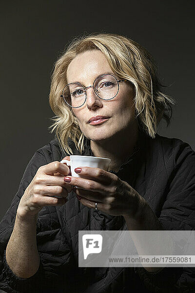 Porträt selbstbewusste blonde Frau beim Kaffeetrinken