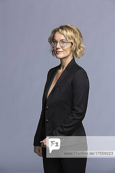 Studio-Porträt selbstbewusste blonde Geschäftsfrau mit Brille im Anzug