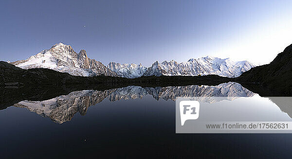 Schneebedeckte Gipfel des Mont-Blanc-Massivs spiegeln sich im klaren Wasser des Lacs de Cheserys in der Abenddämmerung  Chamonix  Hochsavoyen  Französische Alpen  Frankreich  Europa