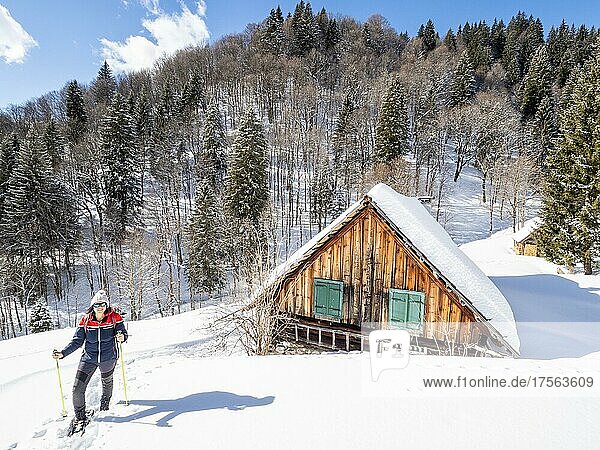 Schneeschuhwanderin in Winterlandschaft  Almhütte im Schnee  Kölblalm  Johnsbach  Nationalpark Gesäuse  Steiermark  Österreich  Europa