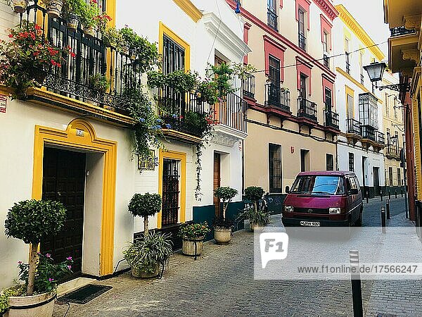 Roter VW Bus auf enger Straße zwischen typischen Häusern in der Altstadt  Sevilla  Andalusien  Spanien  Europa
