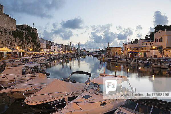 Blick vom Kai über den Hafen in der Abenddämmerung  Lichter spiegeln sich im ruhigen Wasser  Ciutadella (Ciudadela)  Menorca  Balearische Inseln  Spanien  Mittelmeer  Europa