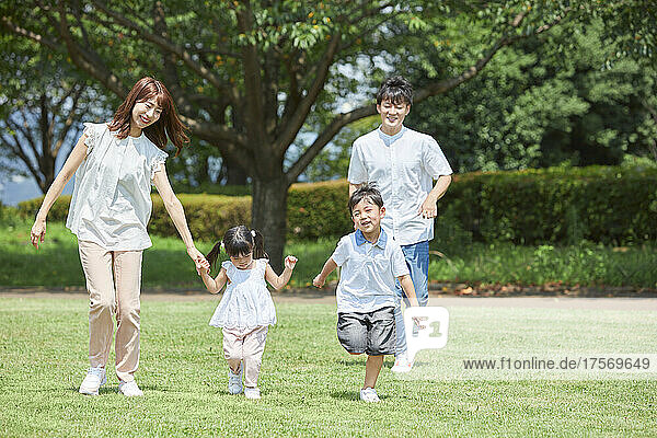 Japanese Family Taking A Walk In The Park