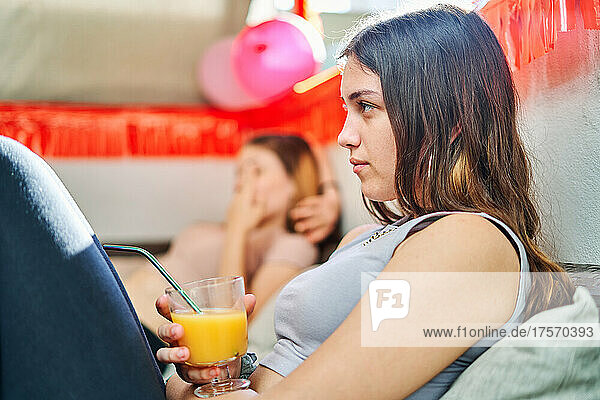 Young women sitting relaxed on the sofa at an outdoor party