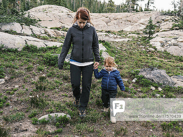 Mother and daughter hiking down from rocks  Colorado