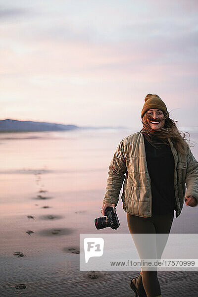 Smiling Young Female Photographer on Oregon beach at sunrise