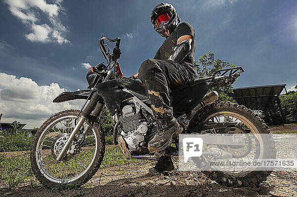 man posing on his dirt bike on race track in Bangkok