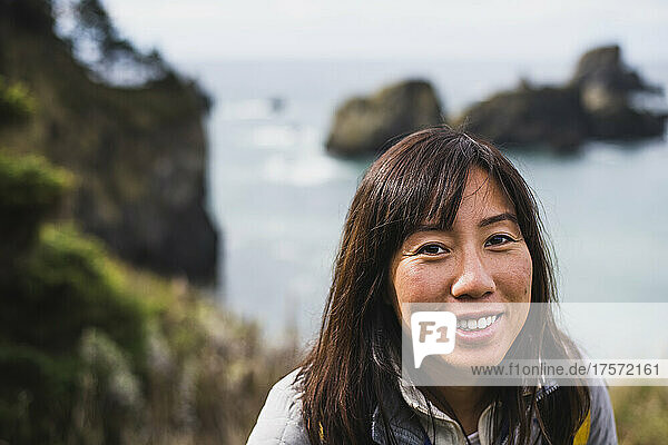 Millenial Female Traveler smiling at camera exploring coastal Oregon