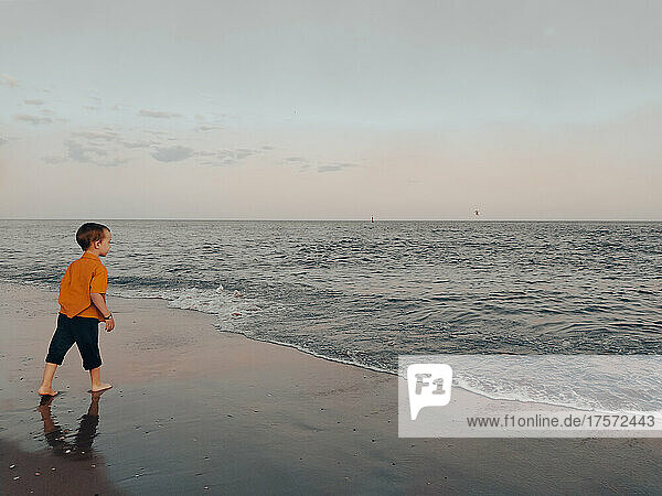 Little boy looks at the sea on the beach