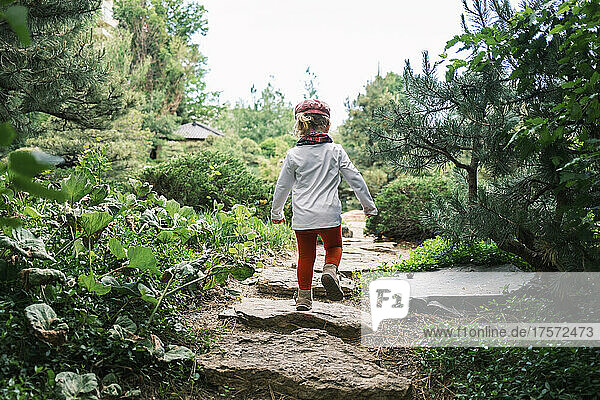 Young child walking on stepping stones in a park