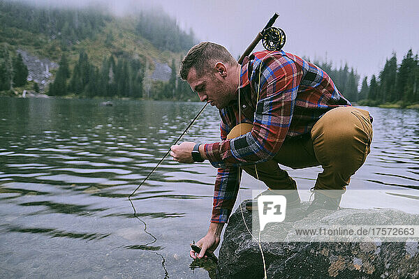 A flannel dressed fly fisherman lands a trout at Lake 22.