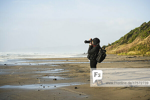 Solo Woman photographing at sunset in coastal Oregon
