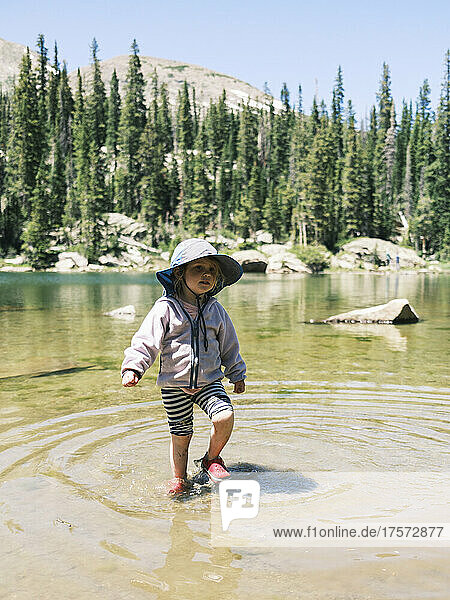 Girl wading in Brady Lake in the Holy Cross Wilderness  Colorado