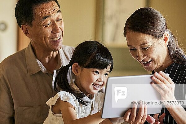 Japanese Grandparents And Grandchildren Using Tablet Devices